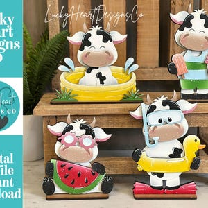 Puede incluir: Colección de figuras de vacas de madera en varias poses de verano. Una vaca está en una bañera amarilla, otra sostiene un helado, una tercera usa gafas de sol con una rodaja de sandía, y la última usa un esnórquel y flota en un pato amarillo. El texto "Lucky Heart Designs Co" es visible.