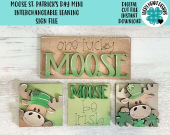 May include: A set of three interchangeable wooden signs featuring a moose with a green hat and shamrock decorations. The signs read "One Lucky Moose", "Moose Be Irish", and a moose with a green hat and shamrock decorations.