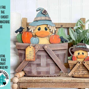 May include: Wooden duck-themed fall decor featuring a large basket with a duck wearing a hat, pumpkins, and crows. A smaller basket with a duck is also present. The text on the image says "Duck Fall for the Flower Basket Interchangeable File".
