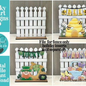 May include: A white picket fence-shaped wooden display with interchangeable holiday-themed inserts. The image shows the fence with a bee-themed insert, a St. Patrick's Day insert, and a spring-themed insert. Text on the image says "Lucky Heart Designs Co."