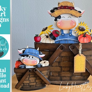 May include: Two wooden basket decorations featuring cartoon cows. The larger basket holds a cow in a straw hat with sunflowers, apples, and pumpkins. The smaller basket holds a cow in a blue hat with a pumpkin. A tag reads FARM FRESH FALL.