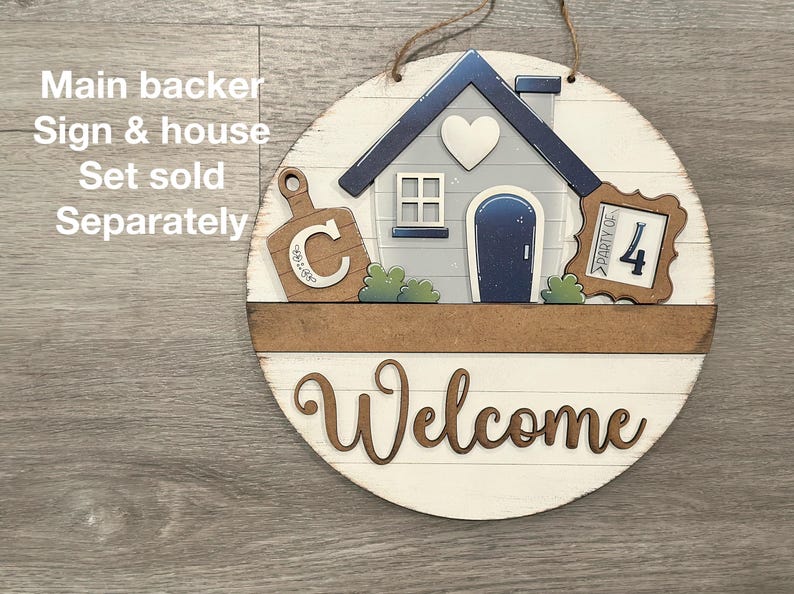 Puede incluir: Un letrero de bienvenida redondo de madera con un dise&ntilde;o de casa y tabla de cortar. El letrero presenta una casa con un coraz&oacute;n, una tabla de cortar con la letra "C" y las palabras "Party of 4". La palabra "Welcome" est&aacute; escrita en cursiva.