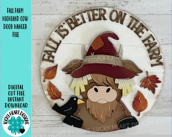 May include: A round wooden sign with the text "Fall is better on the farm" and a cartoon highland cow wearing a scarecrow hat. The cow is brown and white with a black nose and hooves. There are also fall leaves around the cow.