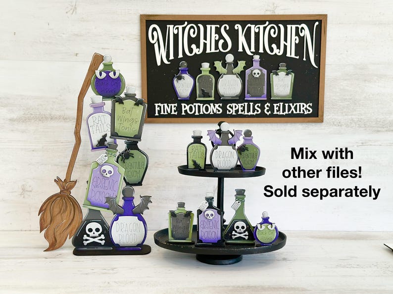 May include: Wooden Halloween decorations featuring potion bottles with labels like "Bat Wings Tonic" and "Dragon Blood." A sign reads "Witches Kitchen, Fine Potions Spells & Elixirs." Includes a broom and a two-tiered tray. The decorations are in shades of green, purple, and black.