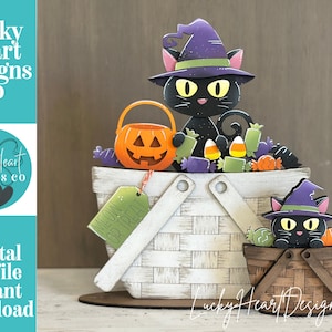 Peut inclure: Une décoration en bois représentant un grand panier blanc tressé avec un chat noir portant un chapeau de sorcière violet, un seau citrouille orange et des bonbons. Un petit panier marron avec un second chat est fixé sur le devant.