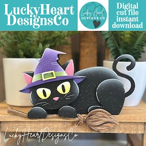 May include: A black cat illustration with yellow eyes and a purple witch hat featuring a green band and yellow buckle. The cat is positioned on a brown broomstick. The text LuckyHeartDesignsCo and Digital cut file instant download are visible.