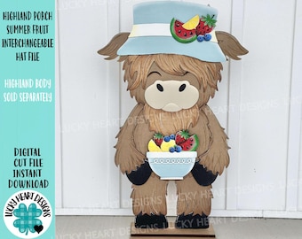 May include: A wooden cutout of a Highland cow with a light blue hat adorned with fruit. The cow holds a bowl of fruit. Text on the left reads "HIGHLAND PORCH SUMMER FRUIT INTERCHANGEABLE HAT FILE".