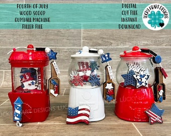 May include: Three red, white, and blue gumball machines decorated for the Fourth of July. Each machine has a wooden scoop and a variety of patriotic decorations, including stars, fireworks, and a flag.