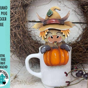 May include: A white ceramic mug with a Highland cow-themed mug hugger. The mug hugger features a cartoon cow wearing a witch hat and holding an orange pumpkin. The text "HIGHLAND FALL MUG HUGGER FILE" is visible. The design is perfect for fall.