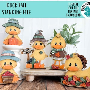May include: A collection of wooden duck figurines with fall-themed decorations. Each duck is painted yellow with orange beaks and feet, and they are adorned with hats, scarves, and autumn leaves. The text "DUCK FALL STANDING FILE" is at the top.