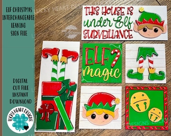 May include: A set of five interchangeable wooden signs featuring a Christmas elf theme. The signs include a red and green elf hat, a pair of elf legs, a sign that says "This house is under Elf surveillance", a sign that says "Elf magic", and a sign with two jingle bells.