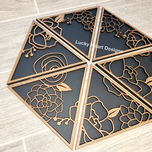 May include: Six black and brown wooden triangular wall decor pieces with floral designs. The pieces are arranged in a hexagonal shape. The text "Lucky Heart Designs" is visible on one of the pieces.