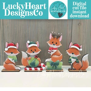 May include: Four wooden fox figurines with festive holiday attire. Each fox has a unique design, including Santa hats, scarves, and reindeer antlers. The image includes the text "LuckyHeart DesignsCo" and "Digital cut file instant download."