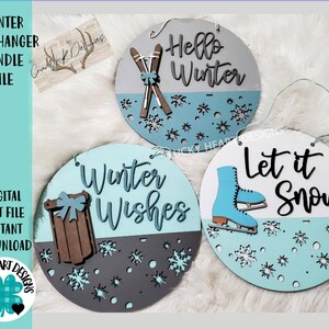 May include: Three round wooden winter door hangers with a split design. The top half of each hanger is painted in a light blue colour with white snowflakes. The bottom half of each hanger is painted in a different colour. The first hanger has a grey bottom half with the text "Hello Winter" and a pair of skis with a bow. The second hanger has a white bottom half with the text "Let it Snow" and a blue ice skate. The third hanger has a grey bottom half with the text "Winter Wishes" and a brown sled with a bow.