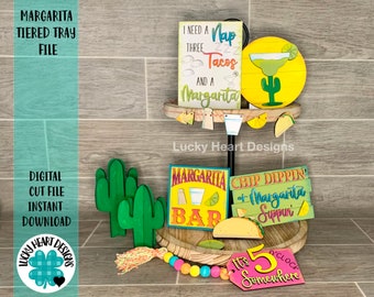 Könnte beinhalten: Ein dreistufiges Tablett, das mit einem Margarita-Thema dekoriert ist. Das Tablett zeigt Schilder mit dem Text "Ich brauche ein Nickerchen drei Tacos und eine Margarita", "Margarita Bar", "Chip Dippin' & Margarita Sippin'" und "Es ist 5 Uhr irgendwo". Es gibt auch Kaktus- und Taco-Ausschnitte.