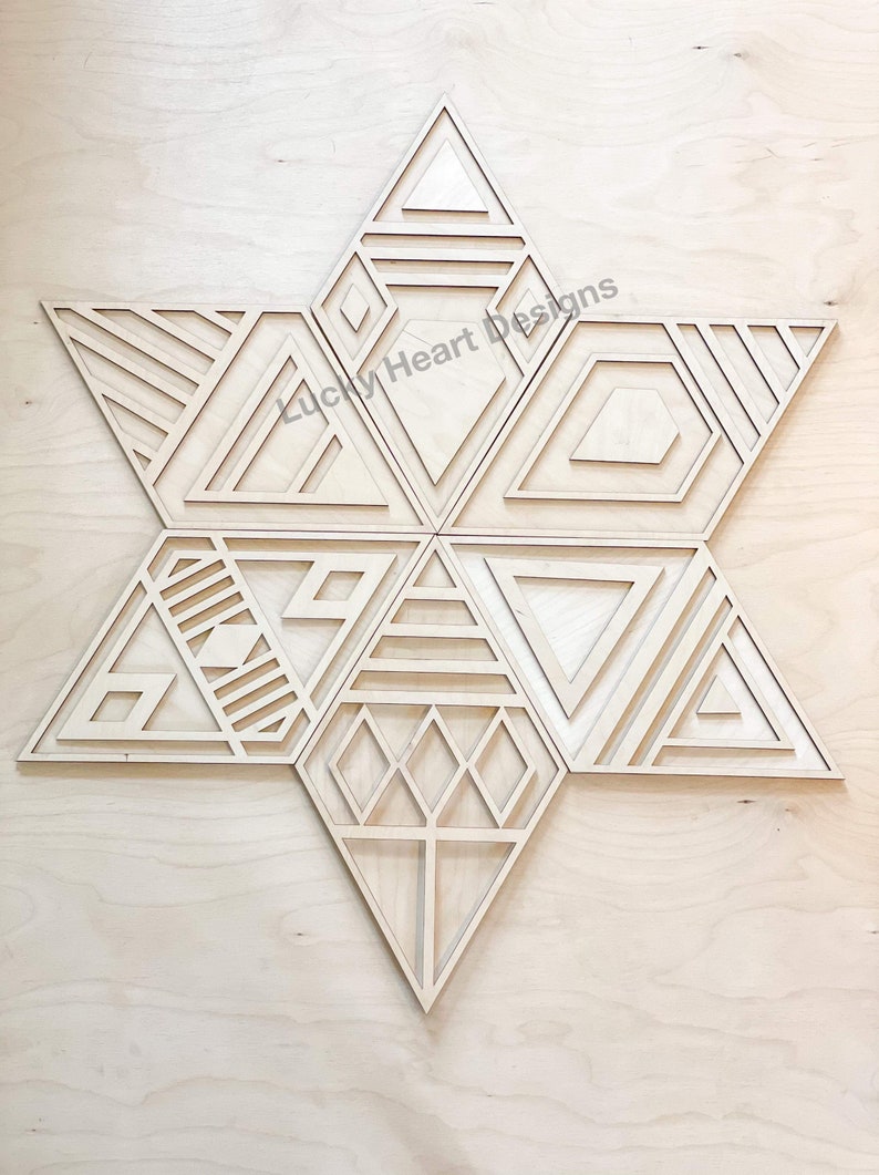 May include: A wooden geometric star wall decor with a variety of intricate patterns and designs. The star is made of multiple pieces that fit together to create a unique and modern look. The star is a light brown color and has a natural wood finish.