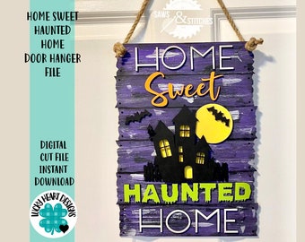 May include: A purple wooden sign with the text "Home Sweet Haunted Home" in white and black lettering. The sign has a black silhouette of a haunted house with a yellow moon and bats.
