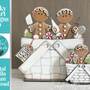 May include: Two white woven-style baskets featuring gingerbread figures, candy, and baking tools. The larger basket includes a brown tag with the white text BAKING SPIRITS BRIGHT. The figures have brown bodies, white icing details, and smiling faces.