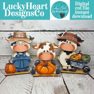 May include: Three wooden cow cutouts with fall themes. The left cow wears a straw hat and blue overalls with a pumpkin. The center cow holds a pumpkin. The right cow wears a brown hat and pushes a wheelbarrow filled with orange and green pumpkins.