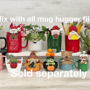 May include: A collection of 10 different mug huggers, each featuring a unique design. The designs include a frog, a gnome, a snowman, a gingerbread man, a witch, a monster, a dog, a woman with glasses, a ladybug, and a worm. The mug huggers are all painted in bright colors and are perfect for adding a touch of personality to your mugs.