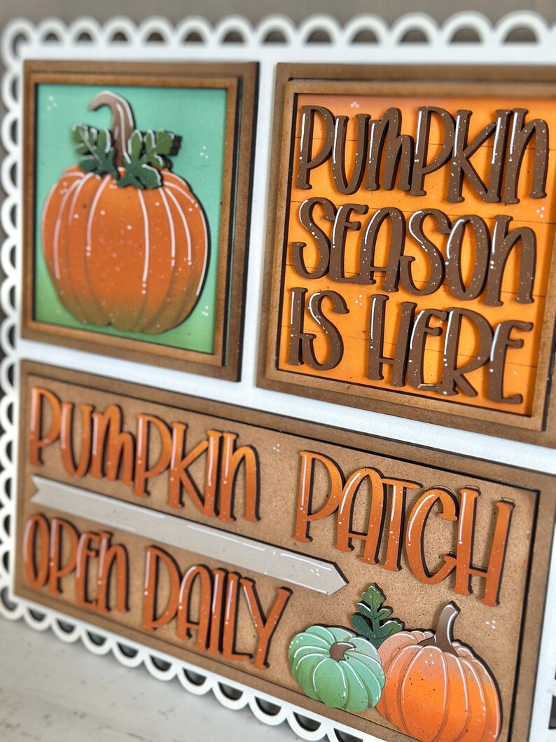 Peut inclure: Panneau d&eacute;coratif en bois avec bordure festonn&eacute;e blanche. Il pr&eacute;sente des citrouilles oranges et les inscriptions &laquo; Pumpkin Season Is Here &raquo; et &laquo; Pumpkin Patch Open Daily &raquo;. Th&egrave;me rustique et automnal.