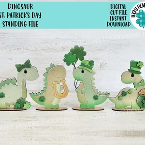 May include: Four green dinosaur figurines with St. Patrick's Day decorations. The dinosaurs are holding a horseshoe, a pot of gold, a shamrock, and a bow. The dinosaurs are standing on a white surface.