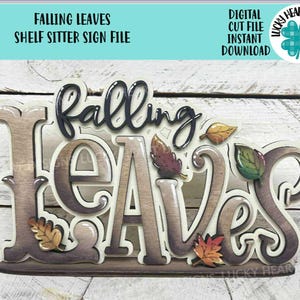 May include: A wooden shelf sitter sign with the words "FALLING LEAVES" in a layered design. The sign features colorful leaf accents and the text "DIGITAL CUT FILE INSTANT DOWNLOAD". The sign is designed for fall decor.