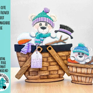 May include: A wooden bear-themed winter basket with interchangeable cutouts. The basket features a bear wearing a hat and scarf, a snowman, and a smaller bear in a wooden bucket. The text on the tag reads "Beary cozy this winter."