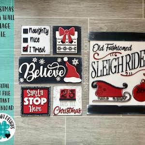 May include: A set of eight Christmas-themed wooden signs painted in red, white and black. The signs feature phrases such as "Believe", "Santa Stop Here", "Old Fashioned Sleigh Rides", and "25 Days Till Christmas".
