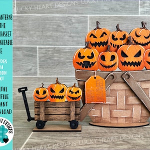 May include: A digital cut file for a Halloween-themed jack-o'-lantern flower basket and a smaller version on a wagon. The basket is filled with orange jack-o'-lanterns with black eyes, noses, and mouths. The basket has a brown wooden handle and a brown wooden base. The wagon has black wheels and a brown wooden bed. The file includes a tag that says "Happy Halloween".