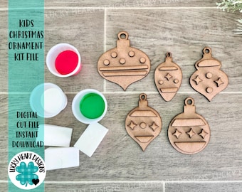 May include: A set of five unfinished wooden Christmas ornament shapes, including a star, a circle, and three different styles of teardrop shapes. The ornaments are arranged on a woodgrain surface with paint supplies, including red, white, and green paint, and white foam brushes.