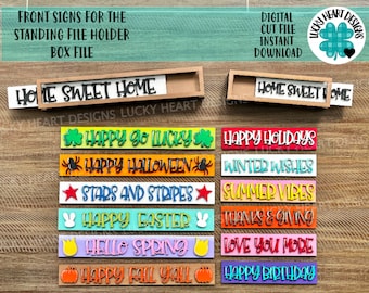 Può includere: Un set di 10 cartelli in legno colorati con vari saluti festivi e stagionali. I cartelli sono progettati per adattarsi a un porta-file in piedi, un box file. I cartelli includono "Happy Go Lucky", "Happy Holidays", "Happy Halloween", "Winter Wishes", "Stars and Stripes", "Summer Vibes", "Happy Easter", "Thanks & Giving", "Hello Spring", "Happy Fall Y'all" e "Happy Birthday".