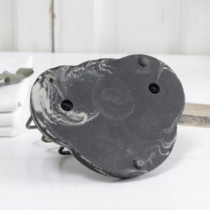 May include: Black and white marbled ceramic base with three holes. The base is shaped like a heart and has a slightly textured surface.