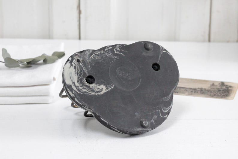 May include: Black and white marbled ceramic base with three holes. The base is shaped like a heart and has a slightly textured surface.