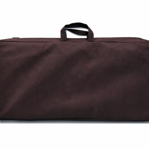 May include: A brown canvas carrying case with a zipper and a single handle.