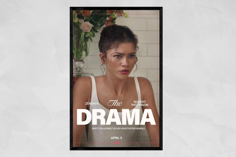 May include: A framed movie poster for "The Drama" featuring Zendaya and Robert Pattinson. The poster has a black frame and a distressed background. The title "The Drama" is in large white letters. The release date is April 3.
