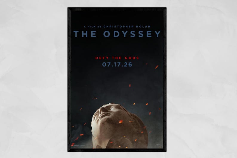 May include: A movie poster titled The Odyssey, a film by Christopher Nolan. The dark background features a stone sculpture of a face looking upward, surrounded by floating embers. Text reads: Defy the Gods, 07.17.26, and studio logos.