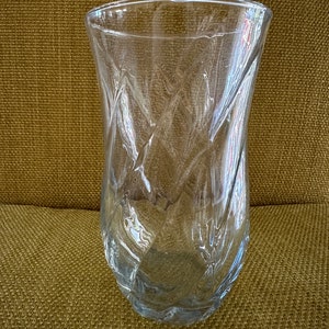 May include: A clear glass vase with a textured, diamond-shaped pattern. The vase is empty and has a wide mouth.