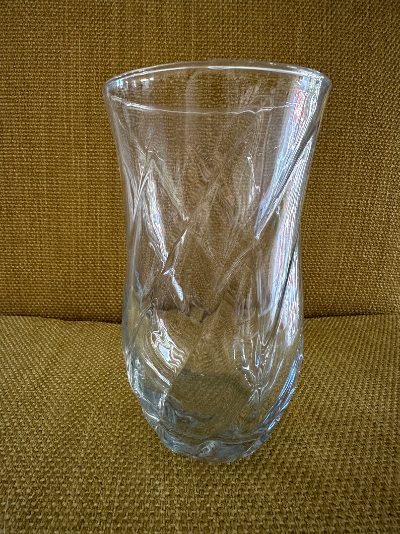 May include: A clear glass vase with a textured, diamond-shaped pattern. The vase is empty and has a wide mouth.
