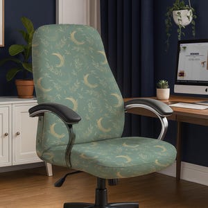 May include: An office chair with a light green fabric featuring a pattern of gold crescent moons and botanical elements. The chair has black armrests and a black base with wheels. The design is modern and suitable for a home office or workspace.