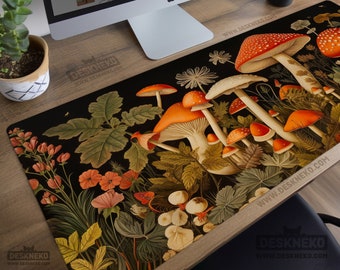 May include: A black desk mat featuring a botanical illustration with orange and white mushrooms, flowers, and foliage. The mat has the text "Aesthetic Desk Mats and Mouse Pads" and "DeskNeko" printed on it. The mat is on a wooden desk with a computer and accessories.