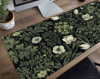 May include: A black desk mat with a floral design in green and white. The mat displays a variety of flowers and leaves, forming a botanical pattern. The text "DeskNeko" is printed on the mat.