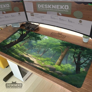 May include: A rectangular desk mat with a forest design, showing a path through trees. The mat is predominantly green and brown, with the text "DESKNEKO" and "WWW.DESKNEKO.COM" printed on it. It is placed on a wooden desk.