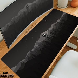 May include: Black desk mat with a minimalist mountain and forest design. The mat features a watchtower, trees, and a crescent moon. The text "WWW.DESKNEKO.COM" is printed on the mat. The DeskNeko logo is in the bottom left corner.