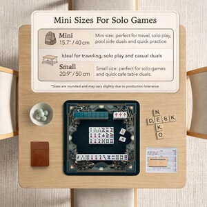 以下が含まれることがあります： 明るい木製のテーブルに麻雀ゲームが置かれています。ゲームは、金と緑のアクセントが付いた濃い青色のマット上にあります。「Mini Sizes For Solo Games」というテキストが表示されています。セットにはアクセサリーが含まれています。
