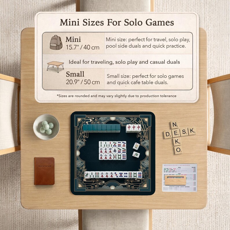 以下が含まれることがあります： 明るい木製のテーブルに麻雀ゲームが置かれています。ゲームは、金と緑のアクセントが付いた濃い青色のマット上にあります。「Mini Sizes For Solo Games」というテキストが表示されています。セットにはアクセサリーが含まれています。