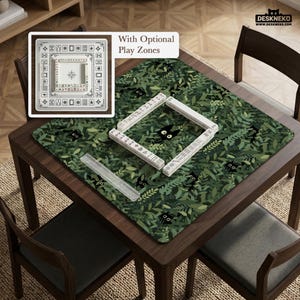May include: A wooden table with a green leaf-patterned mat featuring black cat illustrations. White Mahjong tiles are arranged on the mat. A white square game board with optional play zones is in the upper left corner. The table is surrounded by wooden chairs.