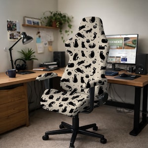 Puede incluir: Silla de oficina negra y beige con estampado de gatos. La silla presenta un fondo beige con siluetas de gatos negros en varias poses. La silla tiene una base de cinco estrellas con ruedas y reposabrazos ajustables.