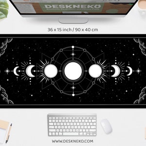 May include: Black desk mat with a celestial design featuring moons, suns, and stars. The mat measures 90 x 40 cm. The design is white on a black background. The website address www.deskneko.com is printed at the bottom.