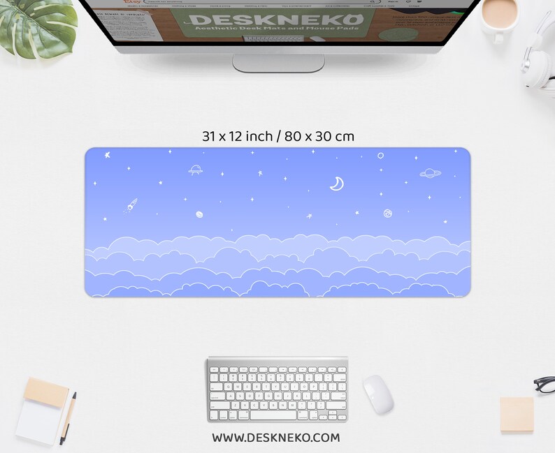 K&ouml;nnte beinhalten: Rechteckige Schreibtischunterlage mit hellblauem Himmelsdesign, 80 x 30 cm gro&szlig;. Die Unterlage zeigt wei&szlig;e Wolken, Sterne, eine Rakete, einen Planeten, einen Mond und ein UFO. Die Website www.deskneko.com ist unten aufgedruckt.